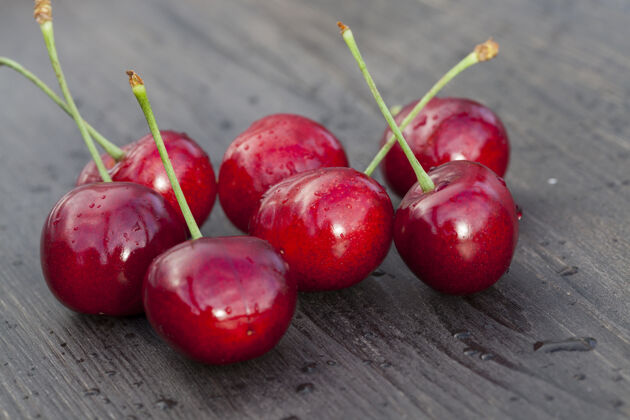 碗一堆红色成熟多汁的樱桃浆果放在木桌上 春天特写新鲜多汁郁郁葱葱