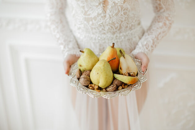 甜点梨子和坚果放在漂亮的盘子里高质量的照片吃手工美味