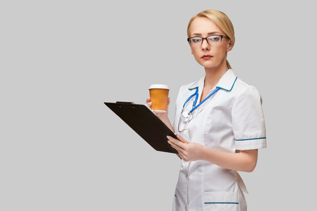 快乐一位女医生拿着一杯纸咖啡 拿着平板电脑的照片外卖电脑紧张