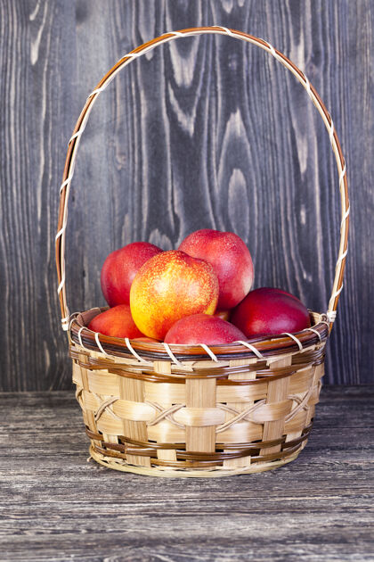 食物一篮又红又多汁的熟桃子 放在厨房的黑桌子上切割农业配料