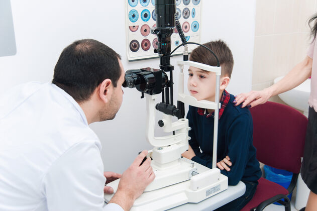 室内孩子和妈妈一起做眼科检查病人专家镜片
