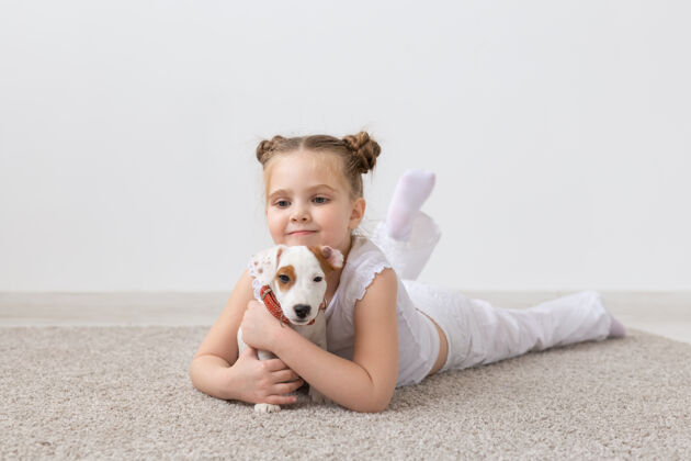 小狗宠物 童年和动物的概念-小女孩在地板上玩小狗杰克罗素宠物有趣玩耍