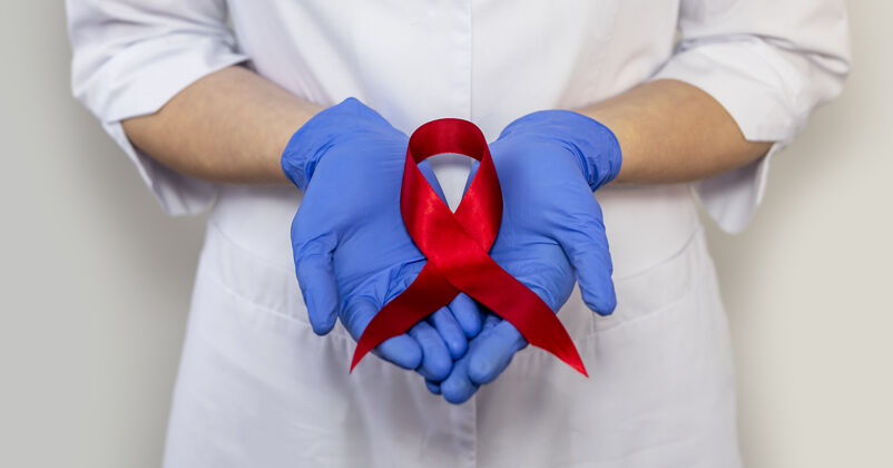 艾滋病红丝带为艾滋病世界日提供支持 医生手戴手套的特写镜头国际医学举行