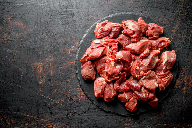 烹饪把生牛肉片放在黑石板上切新鲜配料