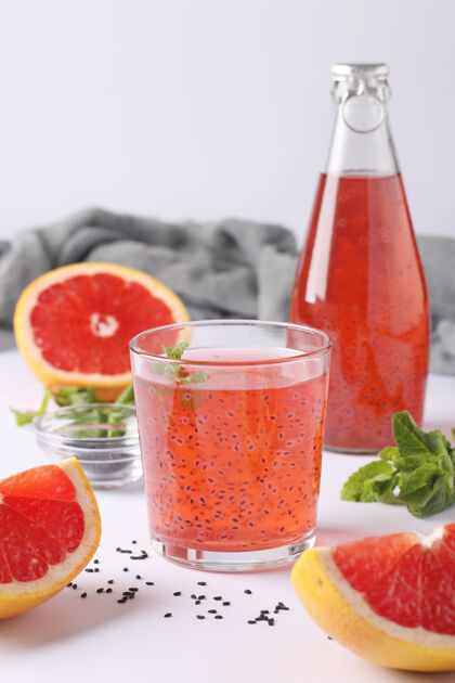 瓶子健康饮料葡萄柚与罗勒种子或法鲁达种子或tukmaria在一个瓶子和玻璃上的白色表面 特写 垂直格式趋势水果素食