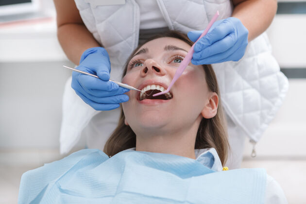 口腔科在诊所接受专业牙医牙科治疗的年轻女子健康牙齿微笑