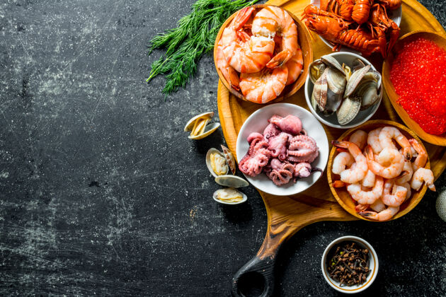 美食海鲜.虾 小龙虾 牡蛎 章鱼和鱼子酱放在砧板上的碗里健康鱼蟹