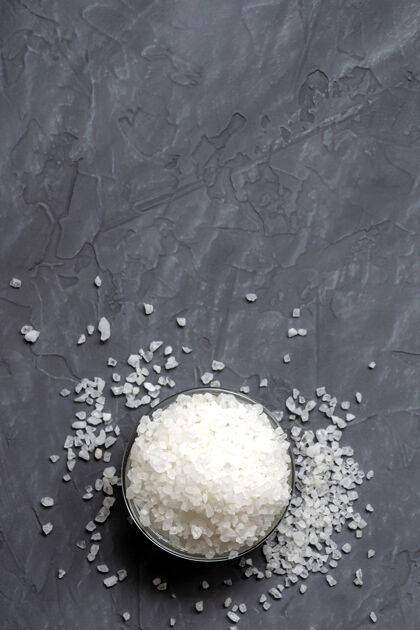 配料特写粗糙的白色海盐在一个玻璃碗里撒在桌子上矿物石头水疗