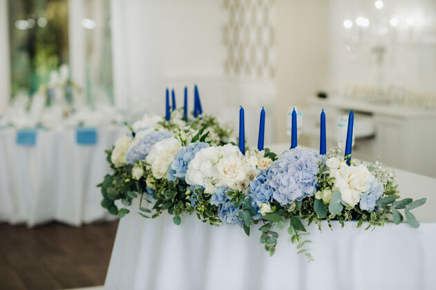 玫瑰婚宴桌上装饰着蓝色的鲜花 在餐厅的餐桌上装饰着婚礼的晚餐优雅蓝色鲜花鲜花