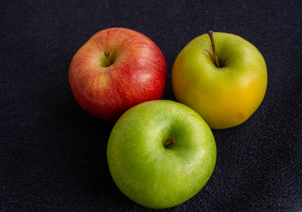诱惑三个苹果 一个是绿色的 两个是红色和黄色的创意食物甜