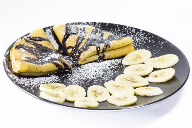 美味巧克力薄饼和香蕉在盘子里 工作室拍摄盘子绉纱烘焙