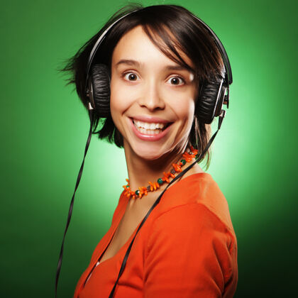 现代年轻快乐的女人戴着耳机听音乐人物女性模特