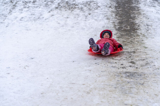 快乐一个小女孩在冬天骑雪橇幻灯片.winter假期霜冻活跃微笑