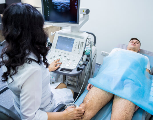 诊所医生用超声波扫描仪检查受伤的膝盖职业保健就诊