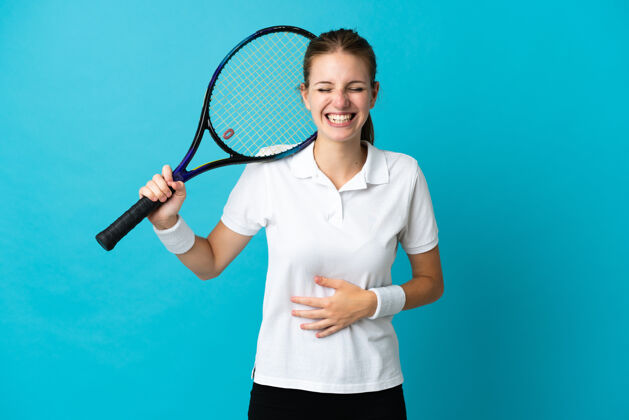 训练年轻的女子网球运动员在蓝色背景下笑了很多活动运动表情