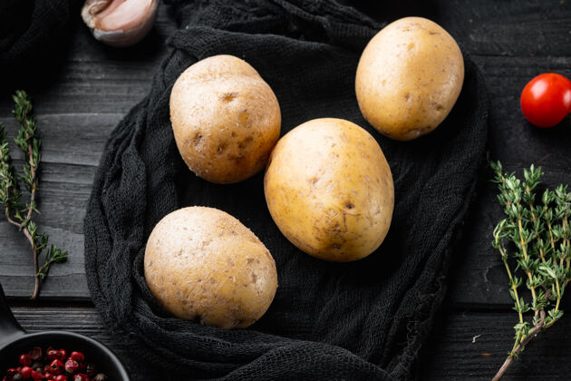 根一堆新鲜的土豆 放在黑木桌上整的配料农场