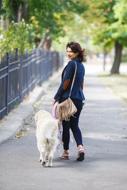 友谊在公园里遛拉布拉多猎犬的女人公园女孩街上有狗关系一起肖像