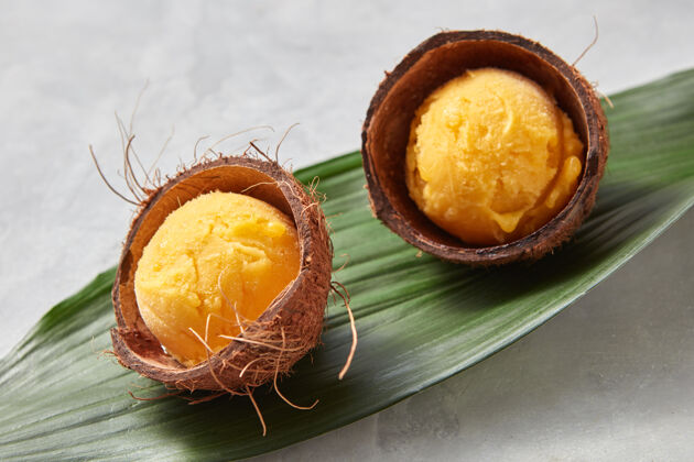 棕榈美味的黄色冰激凌 椰子壳 棕榈叶灰色混凝土表1.夏季甜点.上衣查看顶部球板岩