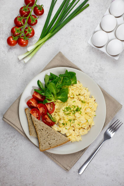 美味炒蛋 西红柿煎蛋卷 面包 沙拉和蔬菜早餐在轻质混凝土上番茄饮食早餐