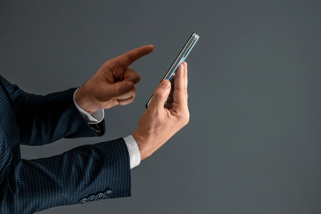 生活方式一个穿着西装的商人的手拿着一个智能手机水平侧视图 用手按压屏幕手指关闭-起来侧线网络手持
