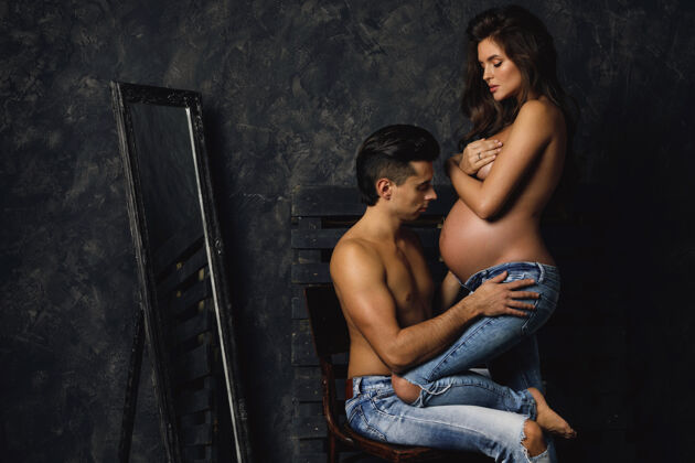 妈妈性感的年轻夫妇在等着宝贝男人还有他怀孕的妻子在室内摆姿势肚子化妆家庭