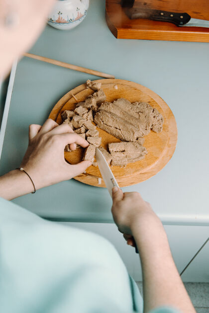创意一个女人一边做饭一边用刀在木制圆板上切豆腐向上蛋白质食客