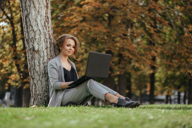女人年轻快乐的商务女士 带着笔记本电脑电脑坐着技术