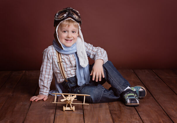 肖像一个戴着飞行员头盔的帅哥和一架木制飞机的画像灵感眼镜自由
