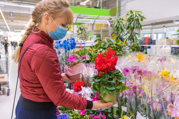 园艺一个女人在花店的花盆里挑选一朵花面具花卉爱好