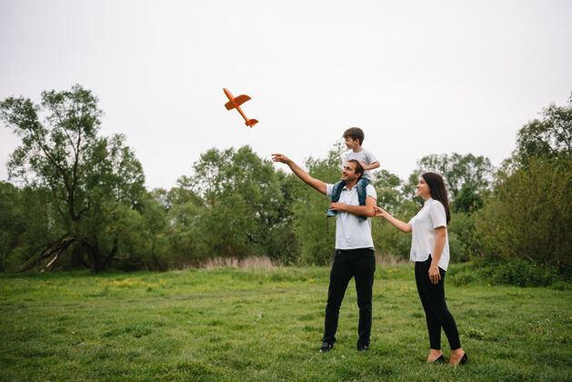 家庭爸爸 妈妈和儿子在公园里玩玩具飞机公园友好型家庭女性休闲户外