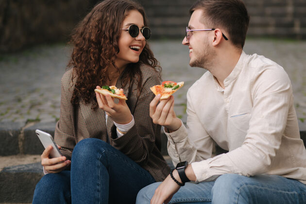 外卖年轻的博客写手拿着一片比萨饼自拍品尝蔬菜意大利