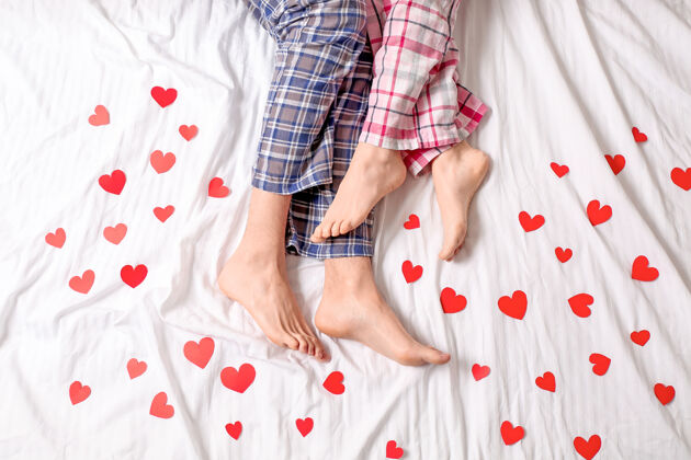 睡衣躺在床上的红心青年夫妇 顶视图床情人节浪漫