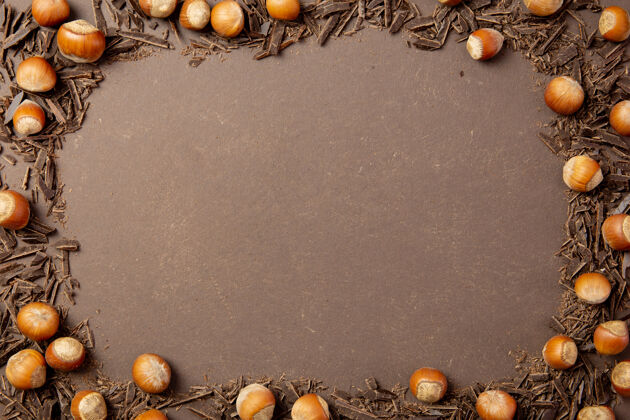 组成切碎的黑巧克力和榛子放在棕色的蛋糕上美食美味零食