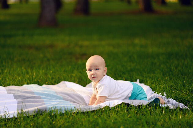 阳光小宝宝躺在夏日公园的草地上 阳光照在脸上格子休息小