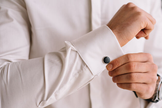 准备穿白衬衫的人穿上袖扣.商务着装要求优雅婚礼男士