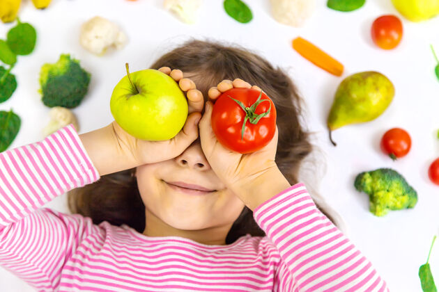 苹果一个手里拿着蔬菜和水果的孩子营养膳食蔬菜