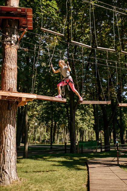 桥梁小女登山者在绳索公园里悠闲操场高学校