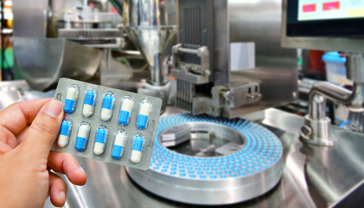 胶囊手持蓝色胶囊包于药丸生产线 工业制药理念工艺医疗保健