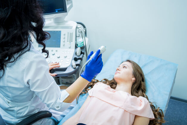 分析医生用超声波扫描仪检查一个女人的甲状腺医院治疗扫描