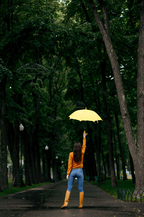 雨伞带伞的女人 背景 夏日公园里的雨 雨天白天女性独自行走的人 小巷里的潮湿天气女性公园保护