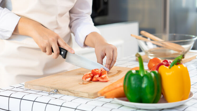 准备年轻的亚洲女人正在准备健康食品蔬菜沙拉 将番茄切在厨房的砧板上 在家里烹饪 健康食品的概念健康餐馆房子