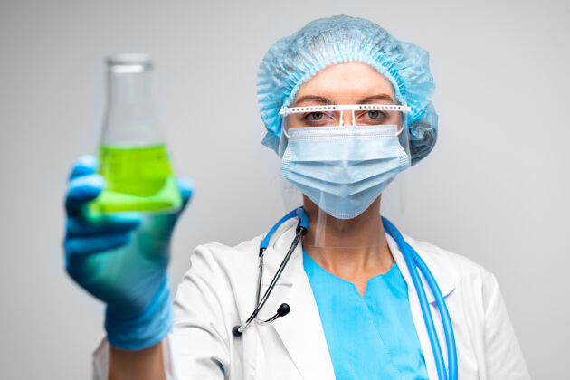 医生女科学家拿着化学液体的实验室烧瓶 灰色背景女人化学液体