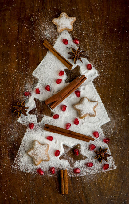 新的自制饼干折叠成圣诞树的形状 肉桂和糖粉放在烤盘上 俯视图饼干棒糕点