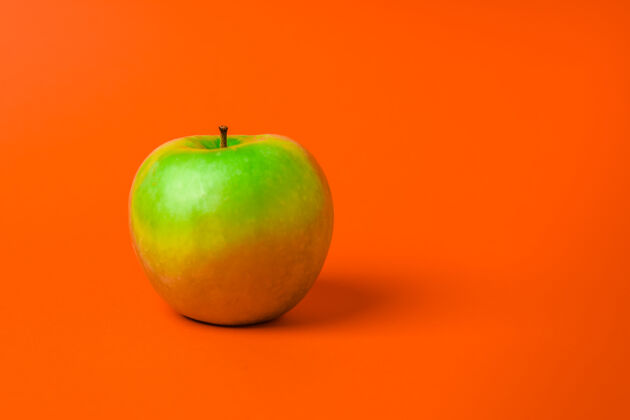 顶部橘子上的青苹果背景极简主义复制空间创意扁平自然