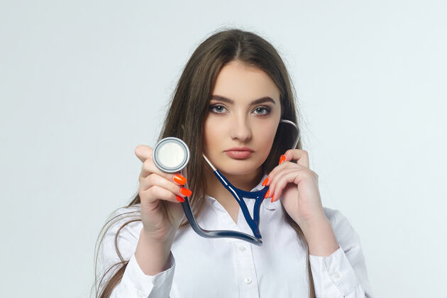 设备一位年轻女医生的画像 白墙上挂着听诊器专家职业保健