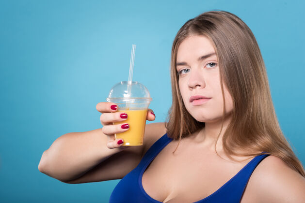 超重我的新饮食关闭年轻漂亮丰满女士展示橙汁塑料玻璃杯的画像女性女人玻璃杯