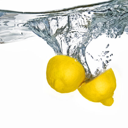 清澈新鲜的柠檬滴入水中 气泡孤立在白色表面柑橘飞溅运动