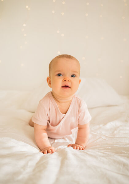 房间穿着粉色紧身衣的小女婴在床上爬粉色可爱婴儿