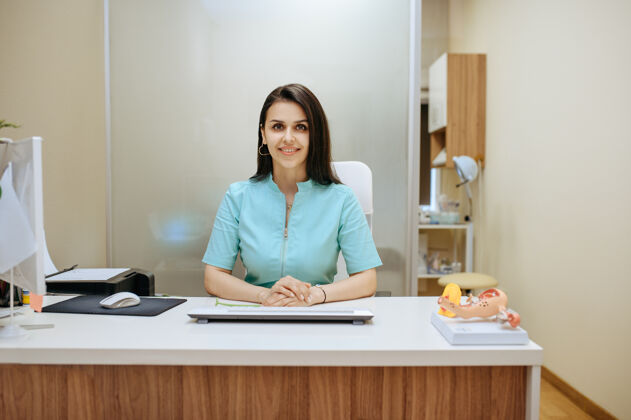 人女妇科医生坐在桌子旁门诊妇科检查或咨询 妇科办公室医生在医院里咨询设备护理