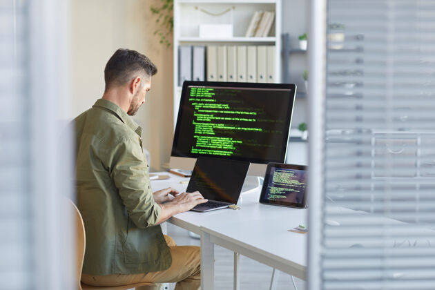 人员成熟的技术人员坐在工作场所的电脑显示器前 在it办公室的笔记本电脑上打字持有职业计算机程序员